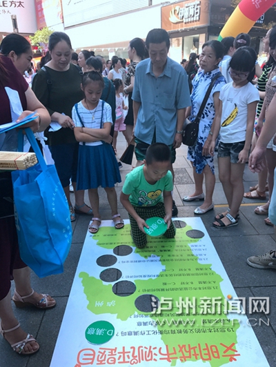 市民在宣傳點(diǎn)參加創(chuàng)文趣味游戲。 記者 朱虹 攝